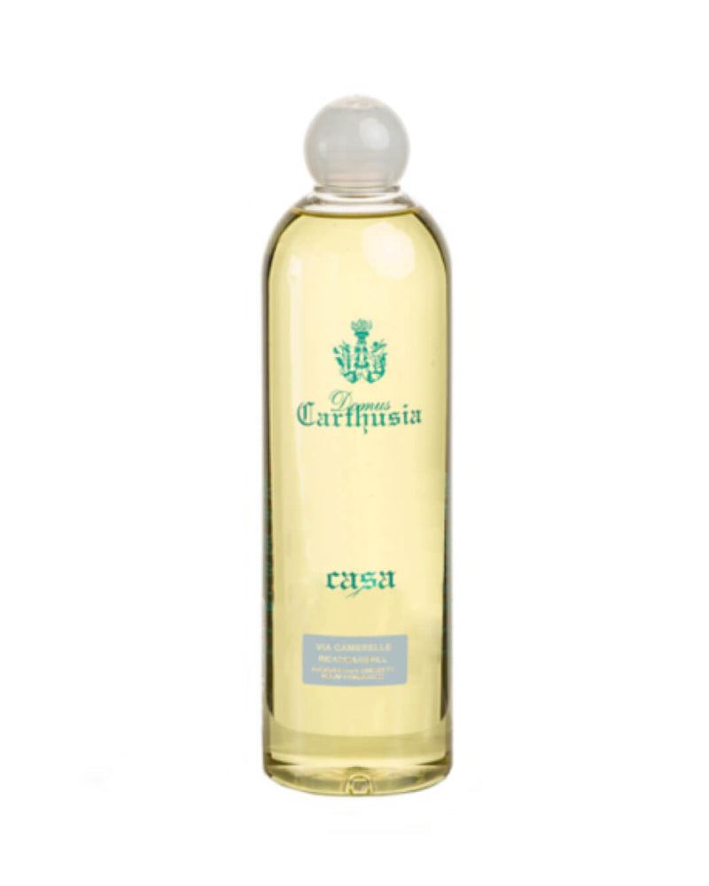 A clear glass bottle with a spherical stopper, containing yellow liquid, labeled "Carthusia Via Camerelle Reed Diffuser - 500ml" in ornate script, designed for use with Carthusia I Profumi de Capri.