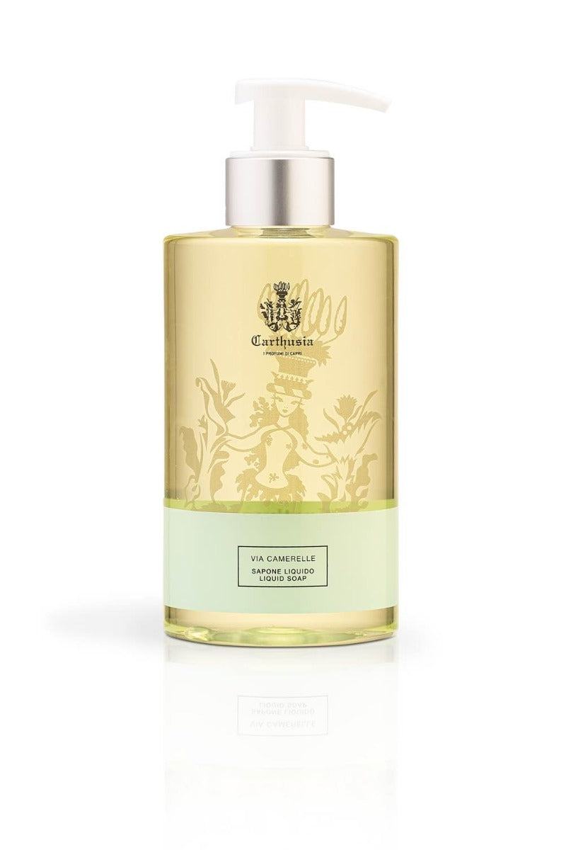 A pump bottle of Carthusia I Profumi de Capri brand Carthusia Via Camerelle liquid hand soap. The bottle is transparent with a two-tone light yellow and green label featuring intricate white designs.