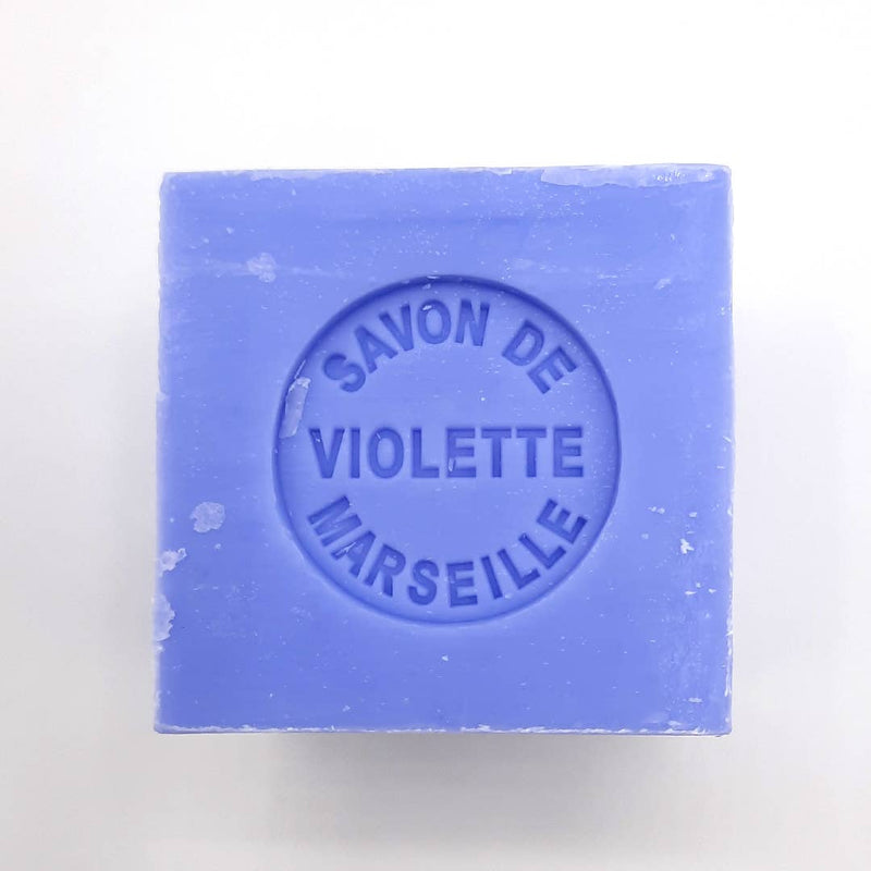 A square, lavender-colored Senteurs De France Marseille Violette Cube Soap with "savon de violette marseille" stamped on its surface, set against a plain white background.
