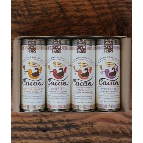 Six cans of Flying Bird Botanicals - Chocolate Lover’s Gift Box with various flavors including lavender, cardamom, and turmeric depicted in front of a wooden background.