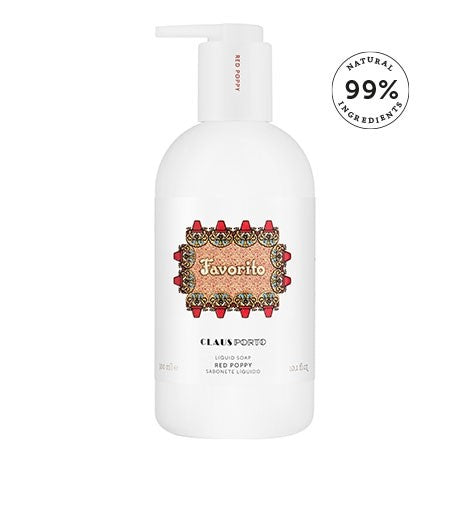 A white bottle of Claus Porto 1887 Favorito liquid soap with a red and gold ornate label. The bottle has a white pump and highlights that the content is made with 99% natural ingredients, including