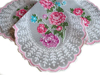 A Vintage-Inspired Hanky - Clover-Shaped Mum Hanky with an embroidered design of pink and blue flowers, featuring intricate lace edges with pink trim, displayed on a clover-shaped handkerchief background by Hankies ala Carte.
