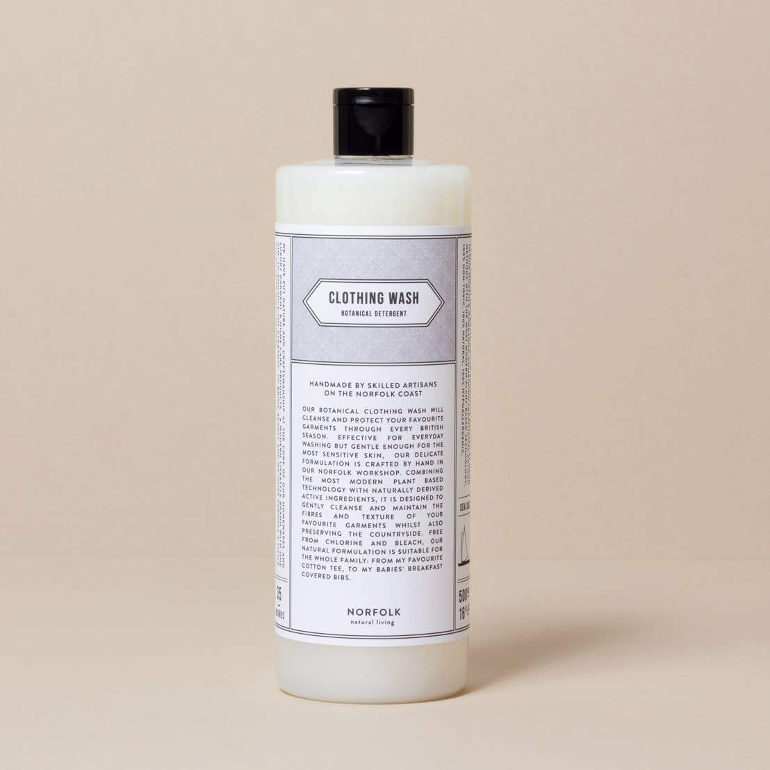 A large white bottle of Norfolk Natural Living Lavender Laundry Detergent with a black cap, featuring a detailed label, set against a plain beige background.