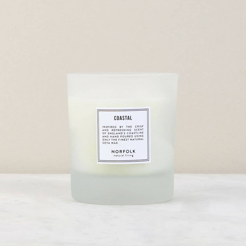 A Norfolk Natural Living Coastal Candle - 8oz labeled "coastal" with text describing its sea salt scent inspired by the north Norfolk coast, displayed against a neutral background.