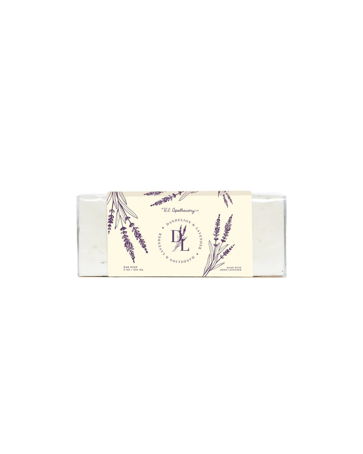 A bar of U.S. Apothecary Dandelion & Lavender Triple-Milled Bar Soap in a white box with lavender illustrations and elegant script text that includes the words "le grandeur," the logo "le," and descriptions in English and French