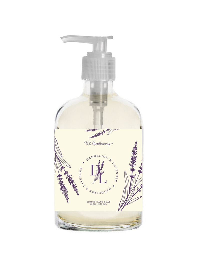 A clear hand soap dispenser with a pump, labeled "U.S. Apothecary Dandelion & Lavender Liquid Hand Soap" in elegant script, decorated with purple lavender illustrations.