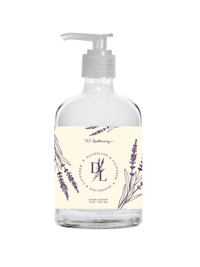 A clear bottle of U.S. Apothecary Dandelion & Lavender Shea Butter Lotion with a pump dispenser, labeled with elegant lavender illustrations and text that reads "lavender & lilac hand lotion – U.S. Apothecary".