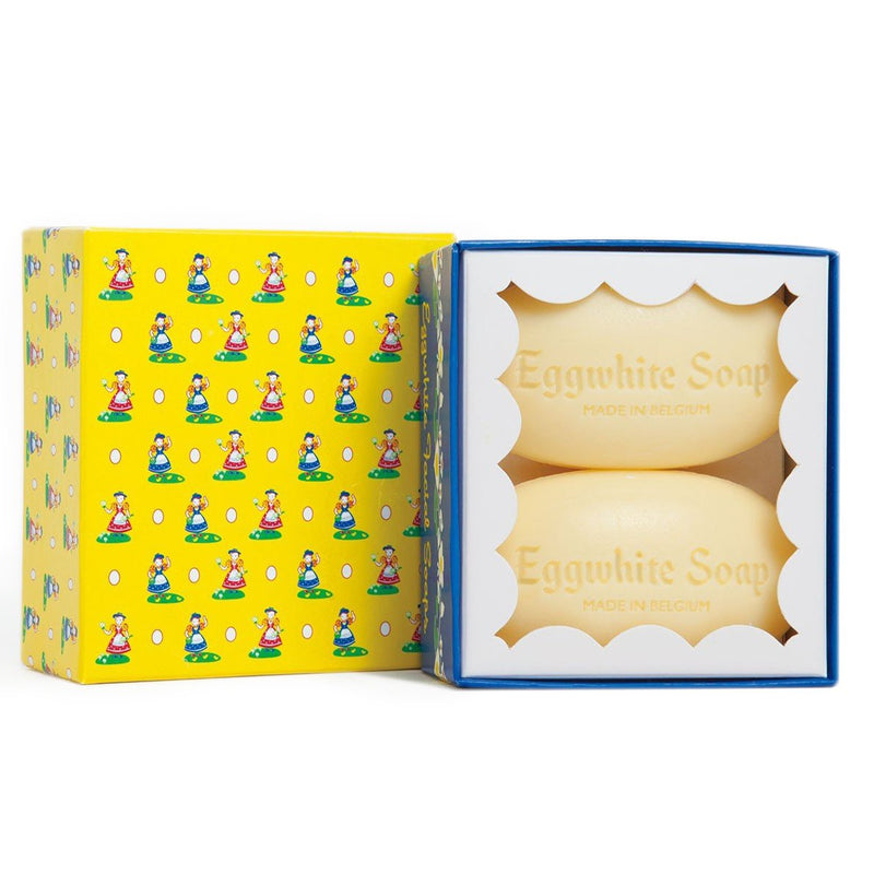 A vibrant yellow box with blue trim and a pattern of little garden gnomes, opened to reveal two bars of "Eggwhite Facial Mask" nestled in a white, cushioned interior from Soaps & Soaks From Around The World.