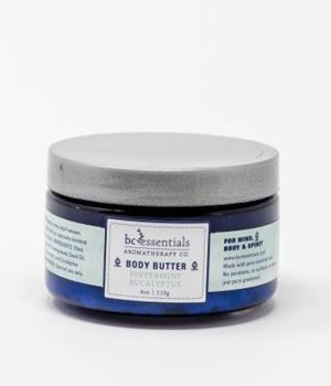 A small, round jar of "BC Essentials -Eucalyptus & Peppermint Body Butter" on a white background. The product label displays the company logo and.