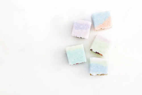 Six Lizush Eucalyptus Shower Steamers arranged on a plain white background, each featuring a different light hue such as lavender, sky blue, and soft pink, crafted with vegan ingredients.