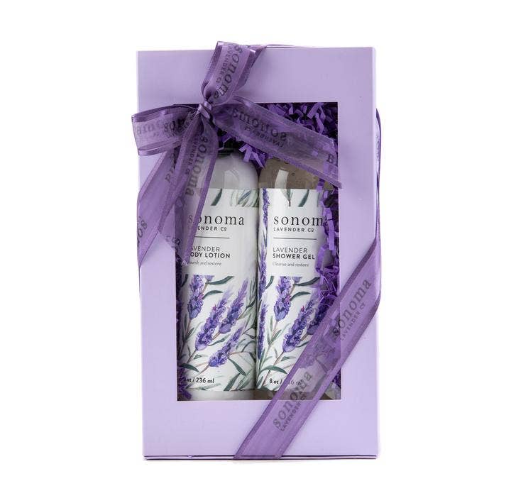 A Sonoma Lavender Shower Gel and Lotion Gift Set, tied with a purple ribbon, containing a bottle of lavender body lotion and a bottle of lavender shower gel, packaged in a lilac box with purple filling.