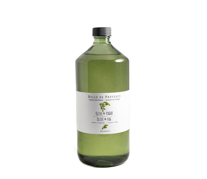 A clear glass bottle containing green liquid labeled "Lothantique Belle de Provence Olive Liquid Soap Refill - Fig", with a black cap, isolated on a white background.