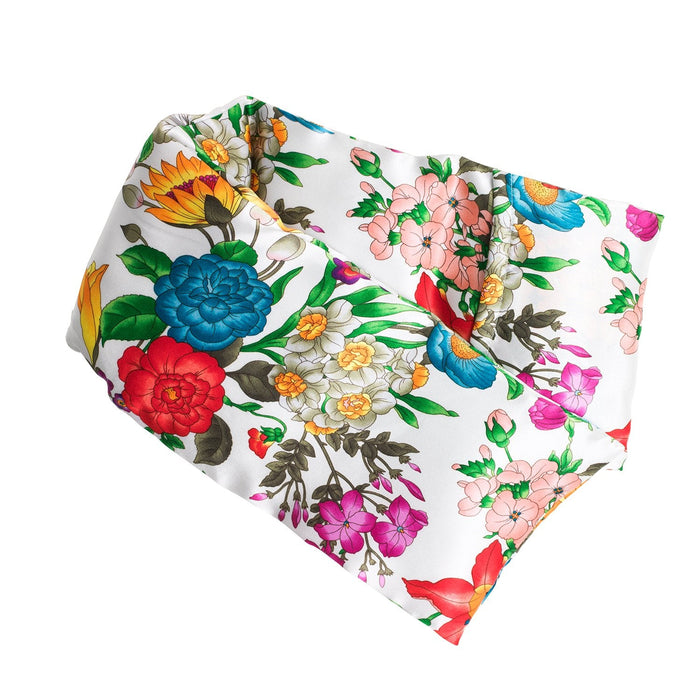The elizabeth W Silk Hot/Cold Flaxseed Pack - Floral Blush is a vibrant floral scarf with flowers in red, blue, yellow, pink, and green on white. It serves as a hot or cold pack by wrapping with flaxseed for soothing natural warmth or coolness.