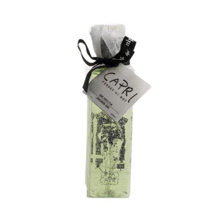 A vertical image featuring a lime green, slender gift box with a gray ribbon and bow. A tag labeled “Carthusia Capri Forget Me Not Shower Gel” hangs on the front, suggesting the contents could be from a boutique or designer by Carthusia I Profumi de Capri.