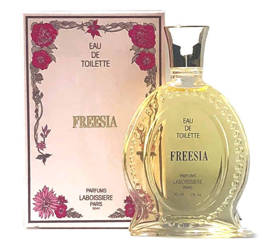 A bottle of Laboissiere Freesia EDT next to its decorative box, which features floral motifs and elegant typeface, highlighting its Laboissiere Parfums Paris origin and fresh scent.