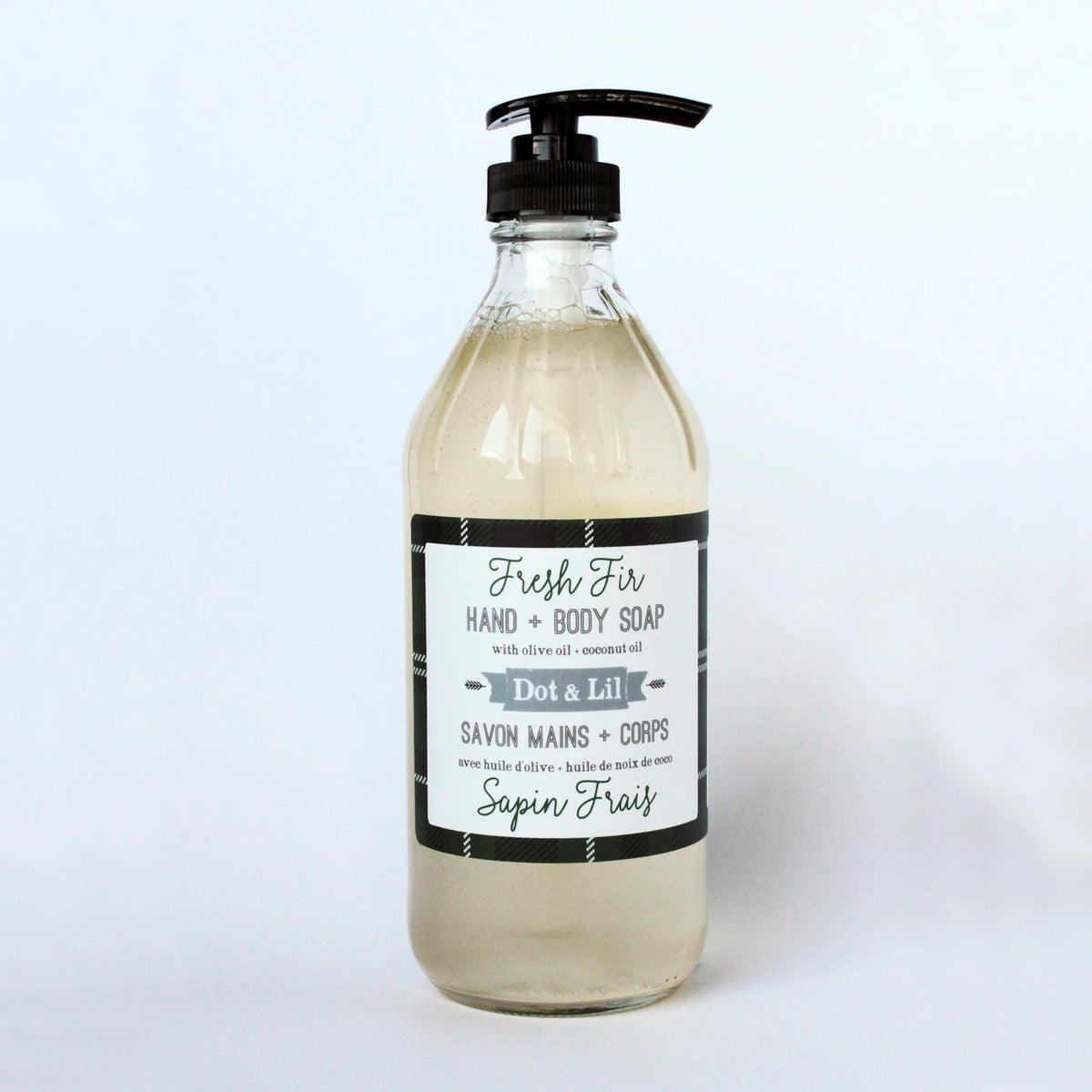 A transparent pump bottle labeled "Dot & Lil Fresh Fir Liquid Soap" containing light amber liquid soap, against a white background.