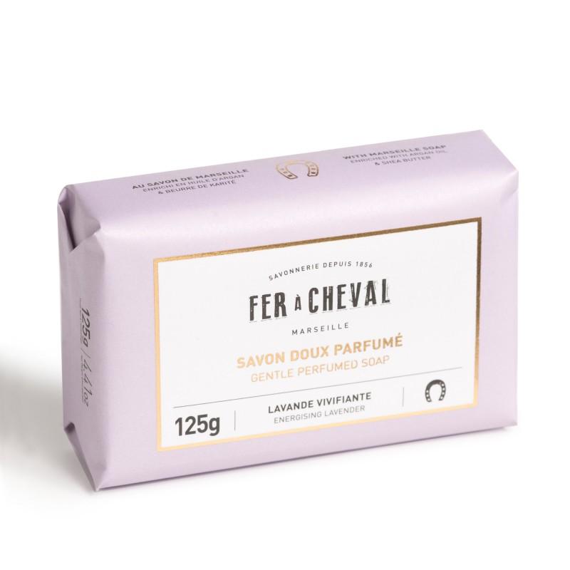A packaged bar of Fer à Cheval soap, gentle perfumed soap in a lavender color wrapper, labeled with "lavande vivifiante, energizing lavender" and weight 125g.