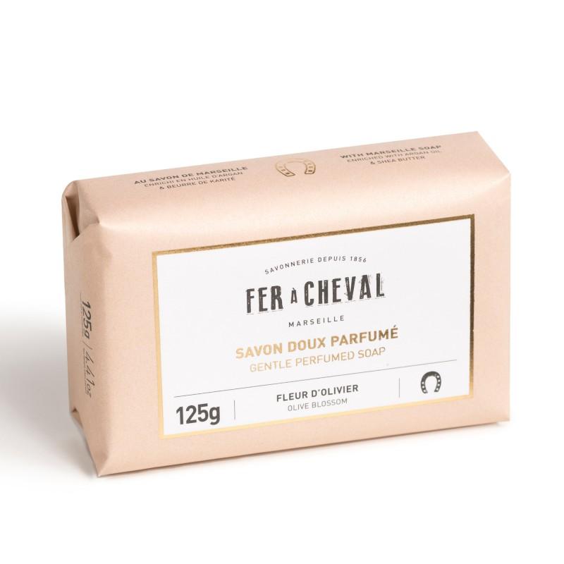 A bar of Fer à Cheval Gentle Perfumed Soap Bar wrapped in beige paper packaging labeled "fer à cheval marseille" with scent noted as olive blossom, indicating a weight of 125g.