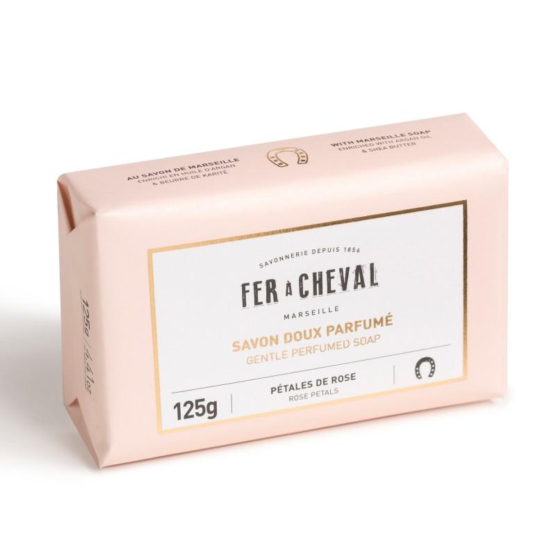 A bar of Fer à Cheval Gentle Perfumed Soap Bar - Rose Petals 125g in a pale pink wrapper, labeled with "pétales de roses" and "125g," against a white background.