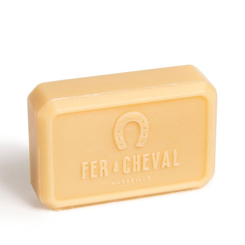 A bar of Fer à Cheval Gentle Perfumed Soap Bar - Rose Petals 125g soap with argan oil in a solid pale yellow color, prominently displaying the Fer à Cheval brand name and logo embossed on its surface, against a white background.