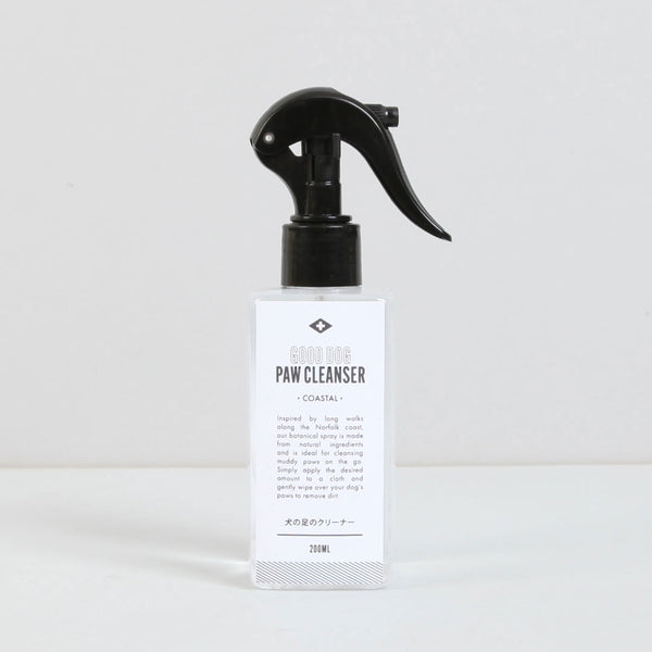 A clear spray bottle labeled "Norfolk Natural Living Good Dog Coastal Paw Cleanser 200ml" with a black trigger nozzle is placed against a plain background. The antibacterial formula is ideal for cleaning muddy paws after walks, and the label suggests its gentle botanical ingredients.