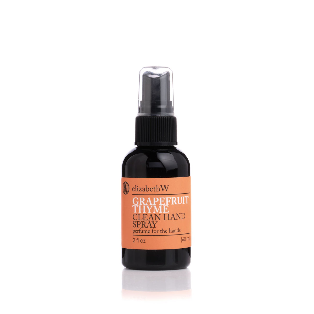 A bottle of elizabeth W Botanical Beauty Grapefruit Thyme Clean Hand Spray with essential oils, featuring a black spray nozzle and label, against a white background.