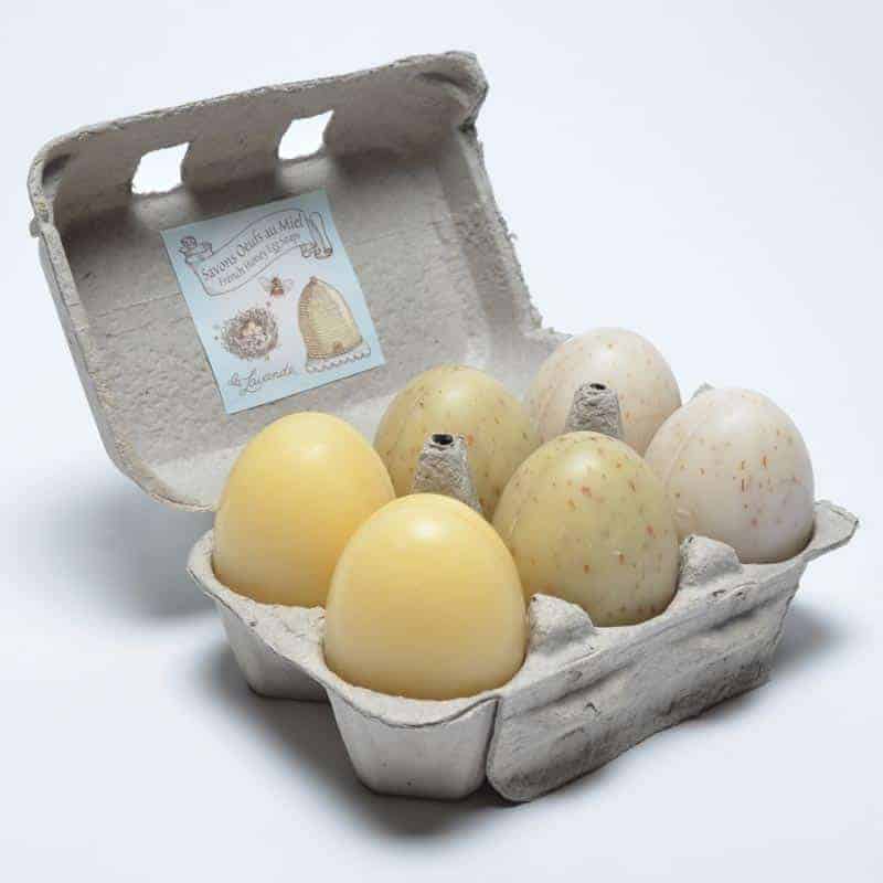 An open La Lavande Egg Carton containing various handmade La Lavande Honey Egg Soaps shaped like eggs against a white background.