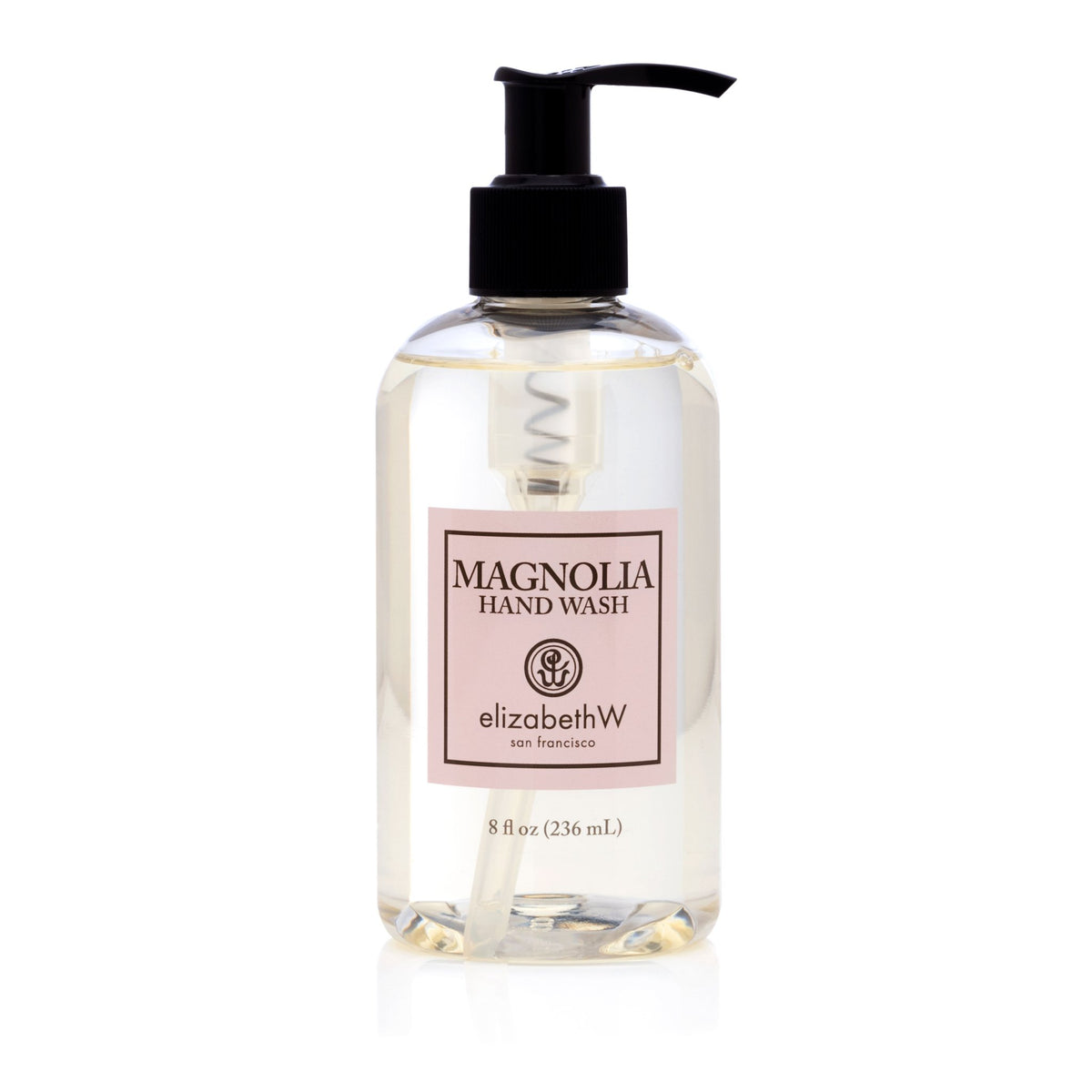 A clear plastic bottle of magnolia petals hand wash labeled "elizabeth W Signature Magnolia Hand Wash," with a black dispenser, isolated on a white background.