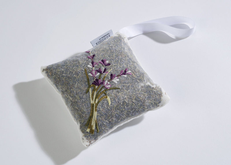 A small, square Sonoma Lavender Linen Hanging Sachet, featuring an embroidered design of lavender stems on one side and a white ribbon loop. The tag reads "Sonoma Lavender." This fresh scent repels insects.