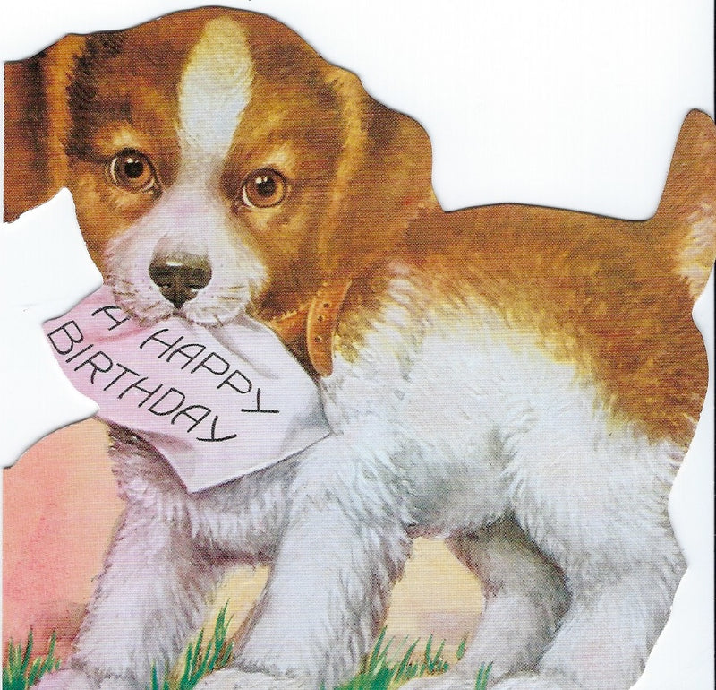 A cute puppy holding a "Happy Birthday" greeting card from Greeting Cards in its mouth, with a playful expression, set against a simple, soft-colored background.