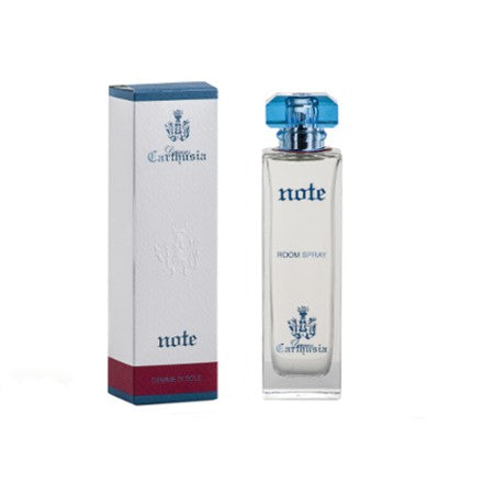 A bottle of Carthusia Gemme di Sole Note room perfume next to its blue and white packaging box with a crest design. The bottle has a clear blue cap and a label reading "Note.
