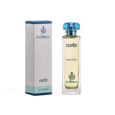 A rectangular blue and white box labeled "Carthusia Via Camerelle Note" next to a transparent glass bottle of "Nute" home fragrance spray with a clear blue cap. Both items feature an elegant crest design by Carthusia I Profumi de Capri.