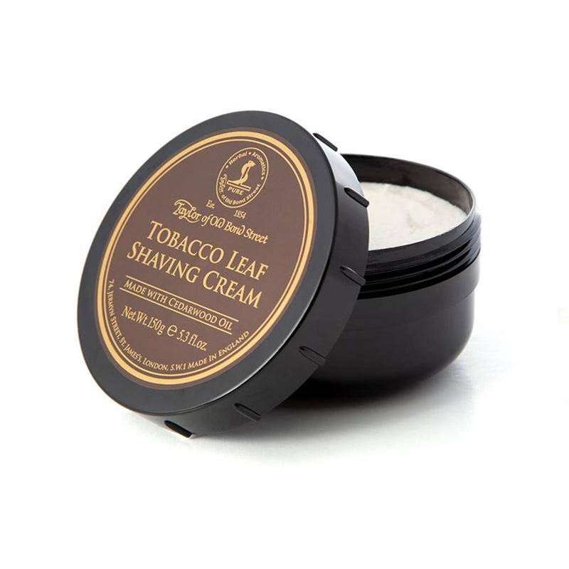 A container of Taylor of Old Bond Street Tobacco Leaf Shaving Cream Bowl 150g open to show its contents, set against a plain white background. The label is black and gold with white text.