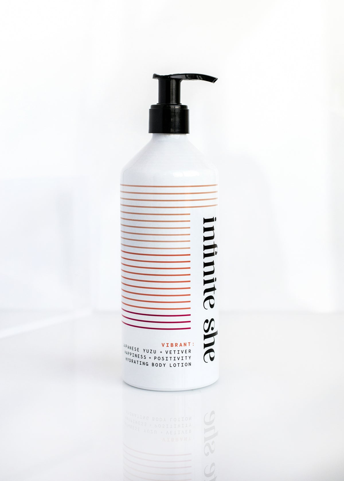 A white bottle of Margot Elena's 'Infinite She Vibrant Hydrating Body Lotion' with argan oil, featuring a colorful horizontal striped design with a black pump, on a clean white background.
