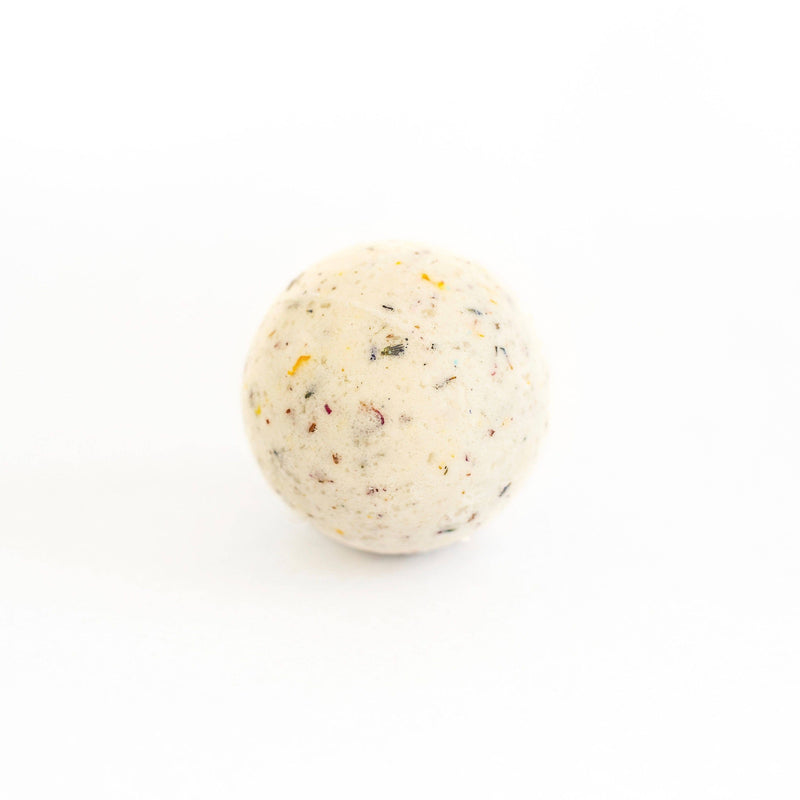 A single vegan-friendly Jasmine bath bomb from SOAK Bath Co. with specks of color, set against a plain white background.