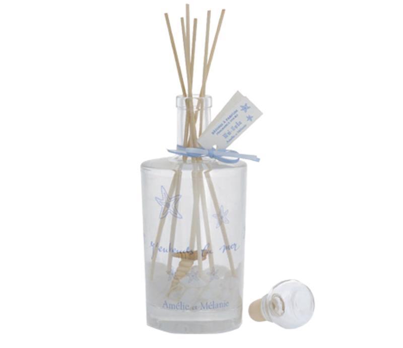 A Amelie et Melanie J'Entends la Mer Fragrance Diffuser bottle with several reed sticks and a decorative tag, adorned with blue ribbons and elegant script writing by Lothantique.