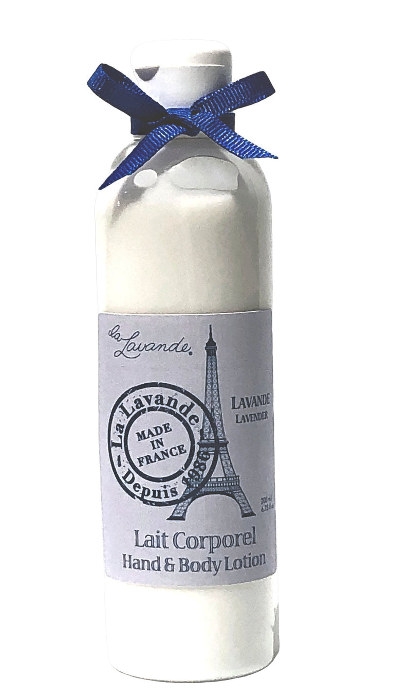 A white bottle of La Lavande Lavender Hand & Body Lotion labeled "lavande made in france" with an image of the Eiffel Tower and a blue bow tied around the neck, enriched with lavender essential oil.