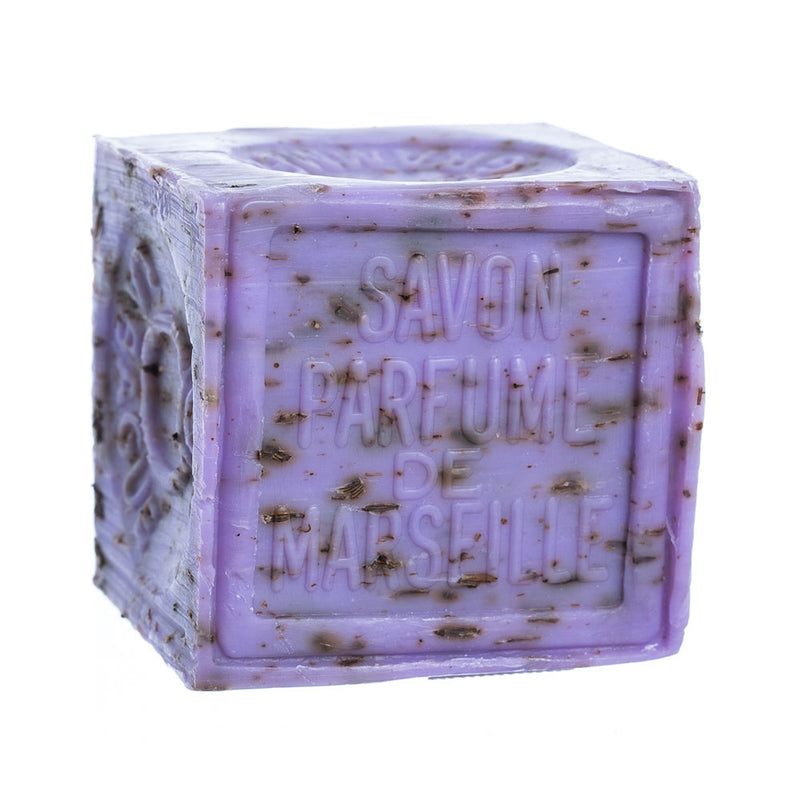 A cube-shaped bar of lavender French Soaps Savon de Marseille with Crushed Flowers soap, designed to exfoliate, isolated on a white background.