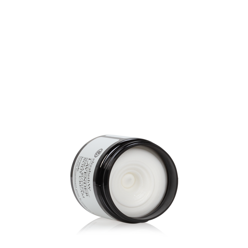 A white jar of elizabeth W Purely Essential Lavender Body Cream with shea butter, featuring an open black lid, labeled in silver text, isolated on a white background.
