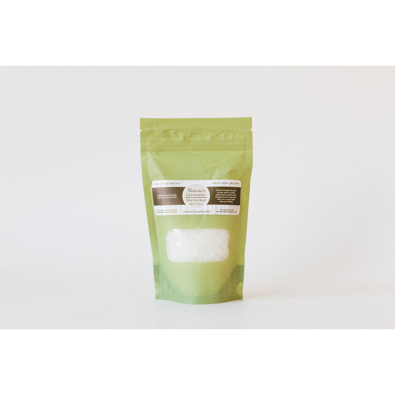 A green and white stand-up pouch with a transparent window displaying Victoria's Lavender - Lavender Eucalyptus Mint Dead Sea Bath Salts, placed against a plain white background.