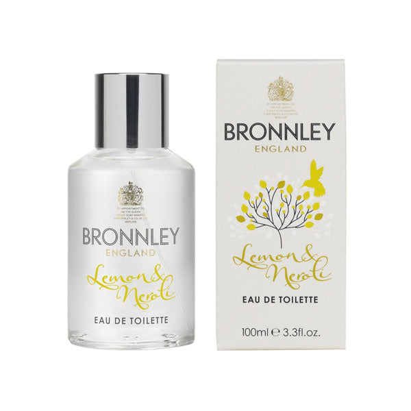 A bottle of Bronnley Lemon & Neroli Eau de Toilette by Bronnley English Soaps next to its packaging box. The bottle is clear with white and gold labels, and the box features a decorative orange blossom.