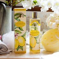Packaging of The English Soap Co. Vintage Lemon & Mandarin Shower Gel with added vitamin E displayed next to a yellow sponge and white flowers, emphasizing a fresh, natural aesthetic.