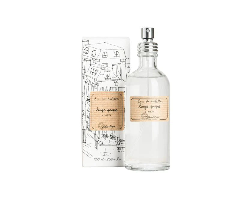 A Lothantique Linen EDT White Package perfume bottle next to its packaging, featuring elegant sketch-style illustrations and labels in French, set against a white background, evoking the classic fragrance.