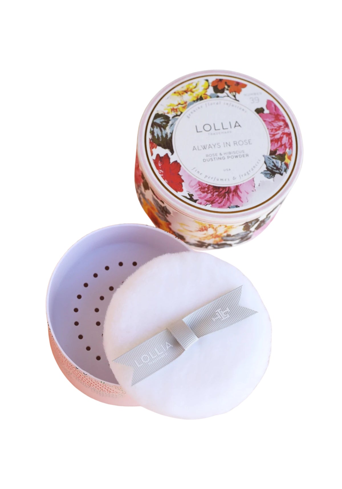 A container of Margot Elena Lollia Always in Rose dusting powder with its lid off, displaying a floral pattern on the label and a powder puff on the side, isolated on a white