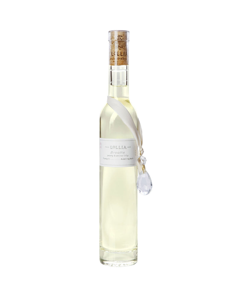 An elegant transparent bottle of Margot Elena's Lollia Breathe Bubble Bath in Glass, featuring moisturizing olive fruit oil, with a white ribbon and a clear crystal pendant, set against a plain white background.