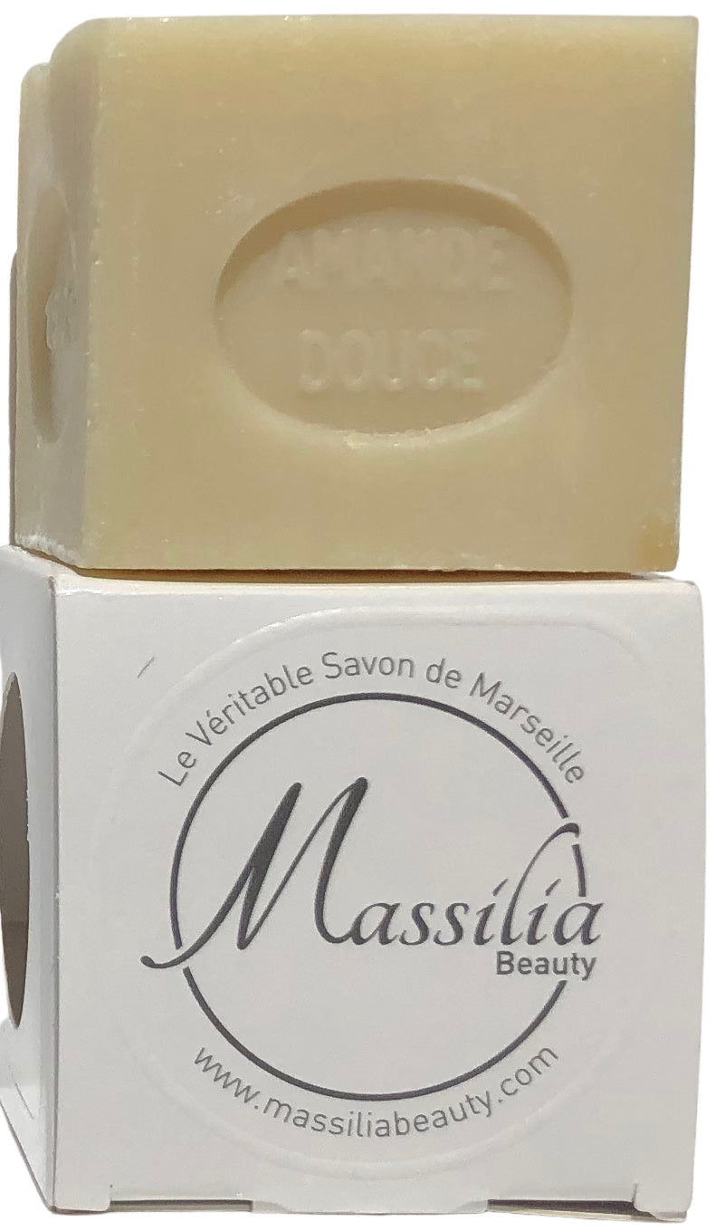 A bar of pale yellow Made in Provence soap labeled "amande douce" on top, resting on its Massalia Beauty branded box with website details visible, crafted using traditional soap making techniques.