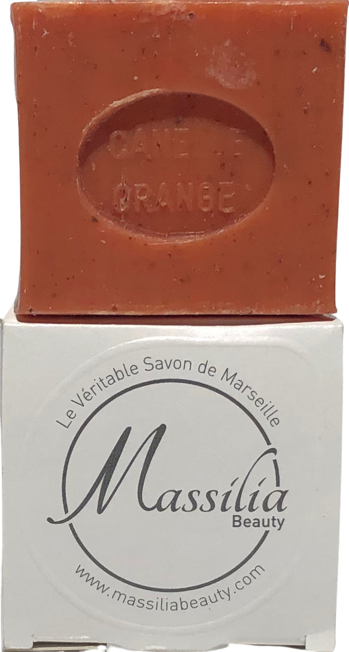 A bar of orange Made in Provence soap labeled "olive & orange" sits atop its white packaging, which displays "le véritable savon de Marseille massilia beauty" and a website address.