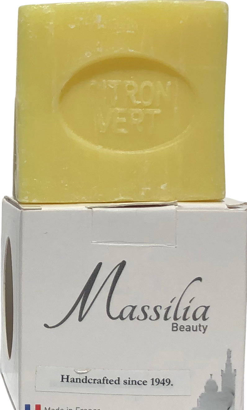 A yellow bar of Made in Provence soap with the words "citron vert" stamped on it, placed on top of its packaging that reads "Massalia Beauty, handcrafted since 1949, made in.