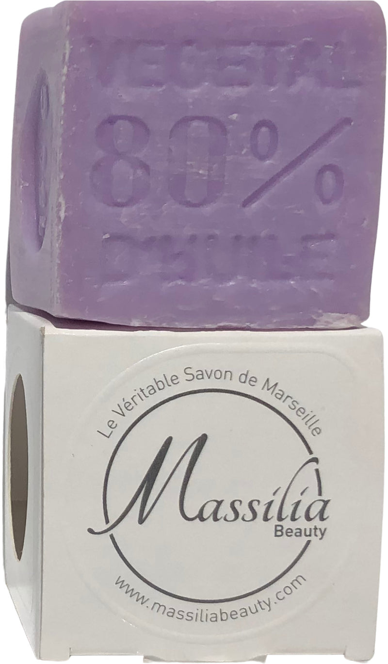 A block of purple Massalia Beauty 150gr Lavender Cube Soap with "80%" imprinted on it, sitting on top of its white packaging labeled "Made in Provence" and the website "www.massiliabeauty.com," infused.
