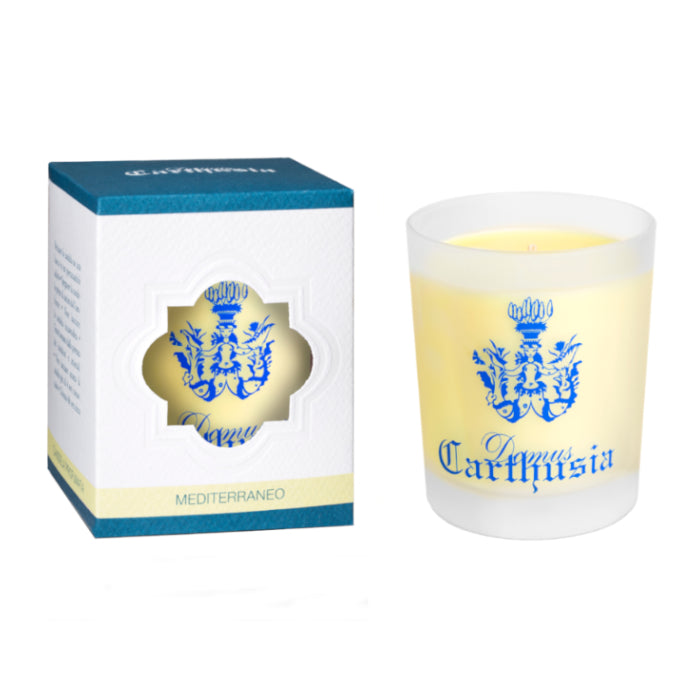 A Carthusia I Profumi de Capri-branded Mediterraneo Candle scented candle next to its packaging box. The box is white with blue accents and features a heart-shaped cutout displaying the candle inside.
